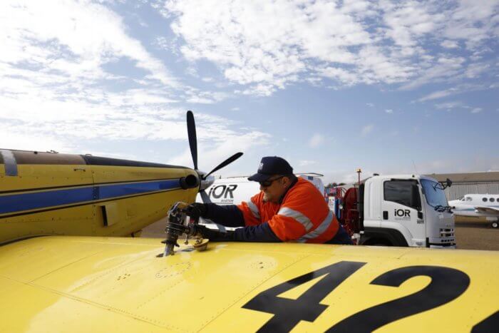 Man wearing high-vis shirt refuelling plane with IOR Aviation fuel tanker